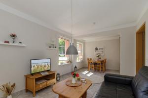 ein Wohnzimmer mit Sofa und Fernseher in der Unterkunft Ferienwohnungen Becker "Sonne & Meer" und "Strandliebe" in Kühlungsborn