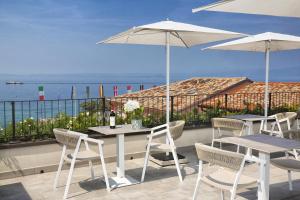a table and chairs with umbrellas on a balcony at I Tre Re in Bardolino