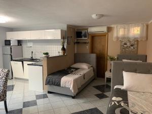 a small bedroom with a bed and a kitchen at Apartments Albatross in Novalja