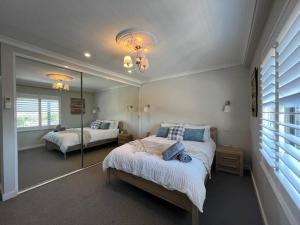 - une chambre avec 2 lits et un grand miroir dans l'établissement STUNNING! TOP FLOOR ROOF TERRACE 2CAR WIFI WINE, à Perth