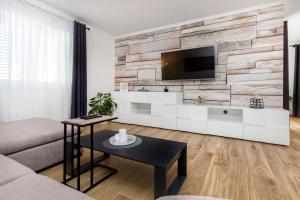 - un salon avec une télévision sur un mur en pierre dans l'établissement Holiday Home Lucia, à Lozovac