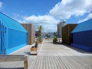 un paseo marítimo con edificios y plantas azules en À da Mamé - Monte Gordo, en Monte Gordo