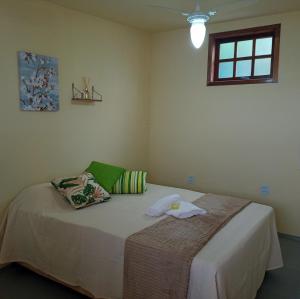 Un dormitorio con una cama con una toalla. en Hostel Guaratiba Casa do Café en Barra de Guaratiba