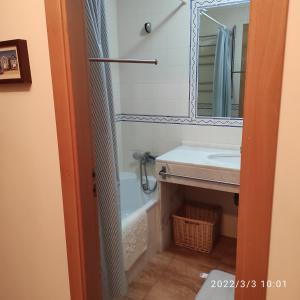 un baño con lavabo y espejo en À da Mamé - Monte Gordo, en Monte Gordo