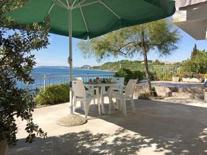 einen Tisch und Stühle unter einem grünen Schirm in der Unterkunft Apartments & Room Paula in Split