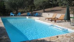 a blue swimming pool with chairs and a raft in it at Holiday Home La Quiete in Alghero