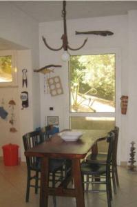 a dining room table with chairs and a window at Holiday Home La Quiete in Alghero