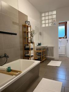 a bathroom with a bath tub and a sink at Wine-Apartment nahe der südsteirischen Weinstraße in Straß in Steiermark