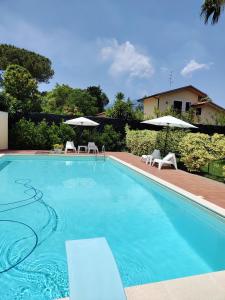 a swimming pool with chairs and umbrellas next to a house at Casa Vacanza Villa Romano in Nicolosi
