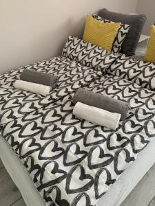 a bed with black and white sheets and pillows at Apartament u Hani in Mosty