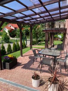 a patio with a table and chairs under a pergola at Apartament u Hani in Mosty