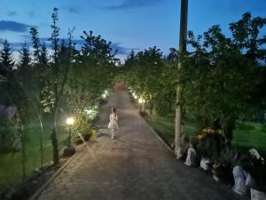 een vrouw die 's nachts over een pad loopt bij Resort Čokori in Banja Luka