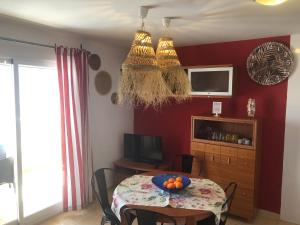 a dining room with a table with a bowl of fruit on it at Apartamentos Playa Torrenostra in Torrenostra