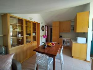 una cucina con tavolo in legno e ciotola di frutta di casa relax a Laveno-Mombello