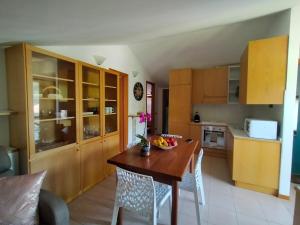 a kitchen with a wooden table with a bowl of fruit on it at casa relax in Laveno-Mombello