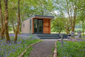 a tiny house in the woods with purple flowers at Ewe pod, luxury glamping pod with hot tub, Croft4glamping in Benderloch