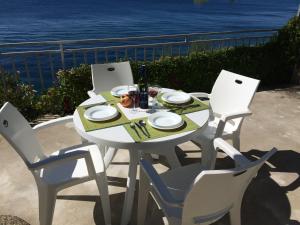 einen weißen Tisch mit Stühlen und einen Tisch mit einer Mahlzeit drauf in der Unterkunft Apartments & Room Paula in Split