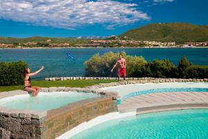 a man and a woman playing frisbee in a swimming pool at Hotel Palumbalza Porto Rotondo in Porto Rotondo