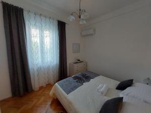 een slaapkamer met een bed en een groot raam bij Apartment Hrzic Malinska in Malinska