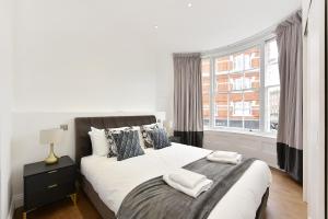 a bedroom with a bed with two towels on it at London Choice Apartments - Chelsea - Sloane Square in London