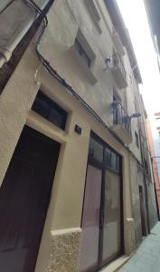 un edificio con porta e balcone di Precioso y acogedor piso en la Seu de Urgell a La Seu d'Urgell