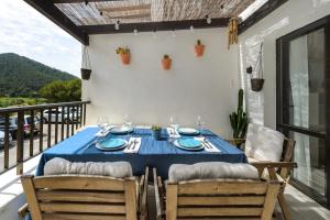 una mesa con un mantel azul en el balcón en Casita en Cala Llonga, en Cala Llonga