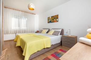 1 dormitorio con 1 cama con manta amarilla en Apartment Vivid, en Pula