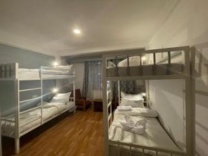 a bedroom with two bunk beds with white sheets at Mellow Fellow Hostel in Gangtok