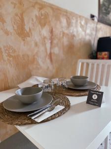 une table avec deux bols et des assiettes dessus dans l'établissement Happy Days Terracina, à Terracine
