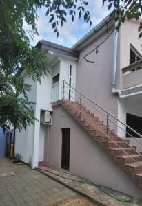 a white house with a staircase on the side of it at Kuća za odmor-Val in Vir