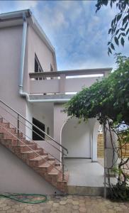 a white house with a staircase and a tree at Kuća za odmor-Val in Vir