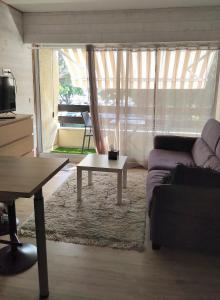salon z kanapą i stolikiem kawowym w obiekcie Studio Andernos vue Bassin port ostréicole charmant et lumineux avec piscine et balcon ! w mieście Andernos-les-Bains