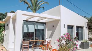 a white house with a table and chairs at Andromahi Apartments & Suite in Laganas