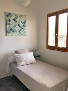 ein Schlafzimmer mit einem Bett in einem Zimmer mit zwei Fenstern in der Unterkunft Mora Dell Onda in Porto-Vecchio