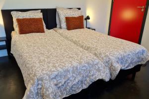 a large bed with a white comforter and pillows at Landkamer in Bolsward
