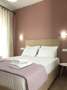 a bedroom with a bed with white sheets and pillows at Tasos Rooms in Prinos