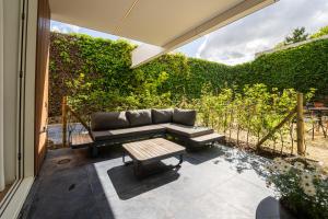 a patio with a couch and a table at Guesthouse de la Paix in Poperinge