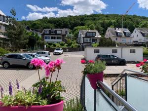 a balcony with pink flowers and a parking lot at La Maison Vintage in Cochem
