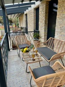 un patio con sillas y una mesa con un bol de fruta en Apartmani CUBE A en Medulin