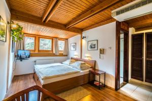 a bedroom with a bed and a wooden ceiling at Szent Kristóf Panzió in Esztergom