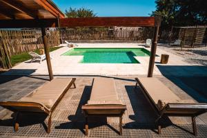 ein Pool mit zwei Liegen neben in der Unterkunft LAS SALINAS GRAN HOTEL in San José de las Salinas