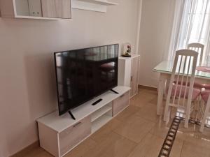 uma sala de estar com uma televisão de ecrã plano num centro de entretenimento branco em Peñuelas Apartment em Lucena