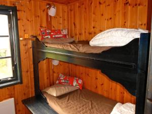 a room with three bunk beds in a cabin at Holiday Home Långberget in Sysslebäck