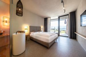 Habitación de hotel con cama y ventana grande en Im Zeitlauf - life with nature en Caldaro