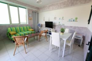 un salon avec un canapé, une table et des chaises dans l'établissement VILLETTA A SCHIERA DUE vicino MALDIVE DEL SALENTO, à Torre Pali