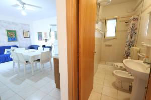 La salle de bains est pourvue d'un lavabo, de toilettes et d'une table. dans l'établissement VILLETTA A SCHIERA DUE vicino MALDIVE DEL SALENTO, à Torre Pali 27 autres photos