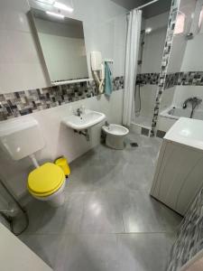 a bathroom with a yellow toilet and a sink at Apartments Paco & Bony in Lovran