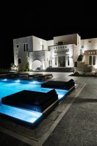 a swimming pool in front of a building at night at Naxian Secret in Naxos Chora