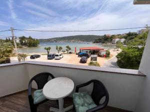 a balcony with a table and chairs and a view of the water at Apartmani Premijer-Rab in Supetarska Draga
