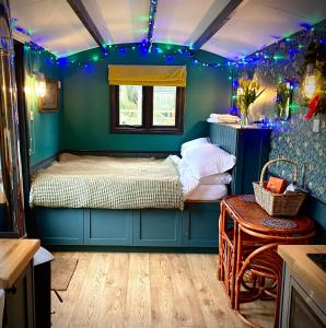 1 dormitorio con 1 cama en una habitación con luces azules en Old King William Shepherd Huts and Private Hot Tubs in North Norfolk, en Hunworth